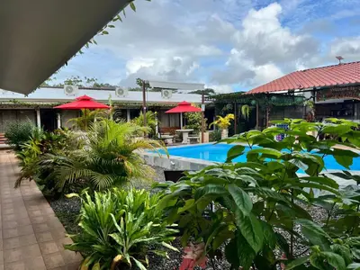 a resort with a swimming pool and some plants at Habitaciones Kolibri in Quepos