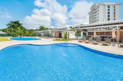 a large swimming pool in front of a building at Upstay - New Condo in Jaco - 5 mins from Beach in Jacó