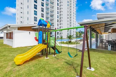 a playground with a slide in a yard at Upstay - New Condo in Jaco - 5 mins from Beach in Jacó
