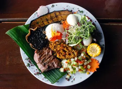 a plate of food with meat and vegetables on a table at Upstay - New Condo in Jaco - 5 mins from Beach in Jacó