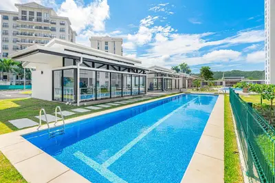 a swimming pool in front of a building at Upstay - New Condo in Jaco - 5 mins from Beach in Jacó
