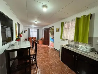 a kitchen with a sink and a table and a couch at Hotel Villa Marsella in Marsella