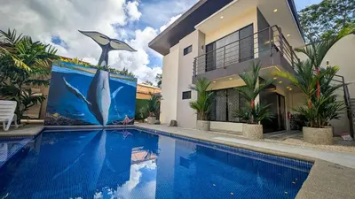 a house with a swimming pool with a mural of a dolphin at Hotel Uvita Forest in Uvita