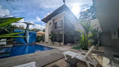 a villa with a swimming pool and a house at Hotel Uvita Forest in Uvita