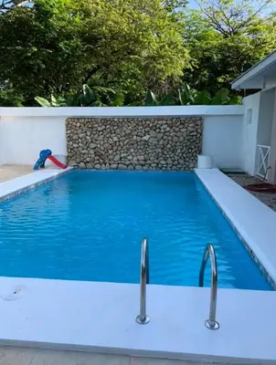 a swimming pool with blue water and two faucets at Manzu in Santa Cruz