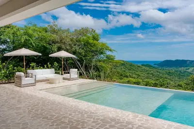 a swimming pool with a view of the ocean at Secluded Luxury Mansion with Sleek, Modern Design, High-End Amenities, and Spectacular Views in Carpintero