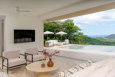 a living room with a white couch and a pool at Secluded Luxury Mansion with Sleek, Modern Design, High-End Amenities, and Spectacular Views in Carpintero