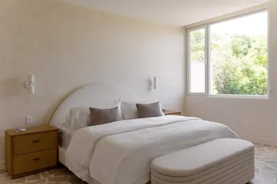 a white bedroom with a large bed and a window at Secluded Luxury Mansion with Sleek, Modern Design, High-End Amenities, and Spectacular Views in Carpintero