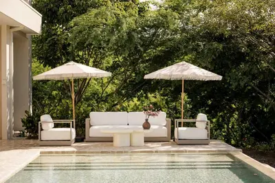 a pool with two white couches and umbrellas at Secluded Luxury Mansion with Sleek, Modern Design, High-End Amenities, and Spectacular Views in Carpintero