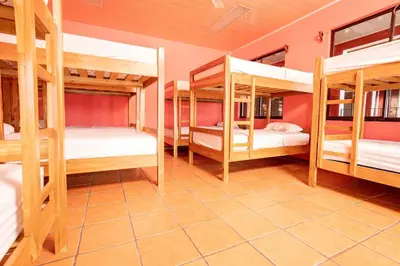 a room with four bunk beds in a house at Hospedaje Papalotes in Quepos