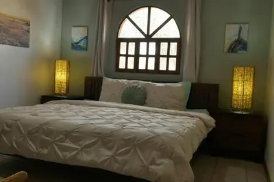 a bedroom with a bed with a window and two lamps at 2bd 2bth Vacation villa in Tamarindo, Costa Rica in Tamarindo