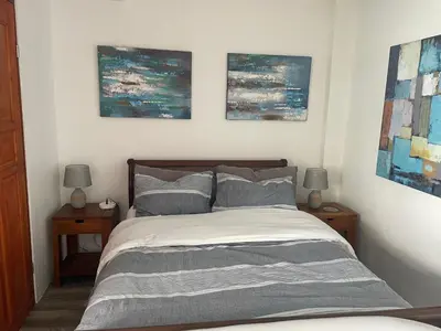 a bedroom with a bed with three paintings on the wall at Palco Pacifico at The Retreat in Atenas