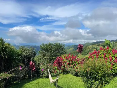a bench in front of a garden with flowers at Palco Pacifico at The Retreat in Atenas