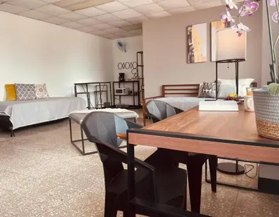a room with a table and a bed and a couch at San Jose Downtown Suites in San José