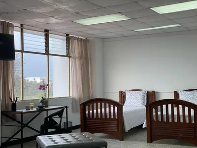 a living room with a bed and a table and a couch at San Jose Downtown Suites in San José