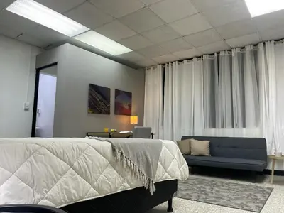 a bedroom with a bed and a blue couch at San Jose Downtown Suites in San José