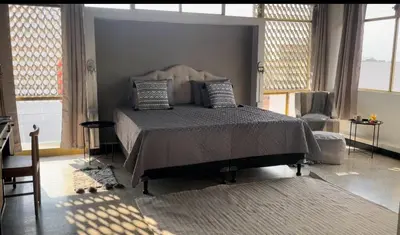 a bedroom with a large bed in a room with windows at San Jose Downtown Suites in San José