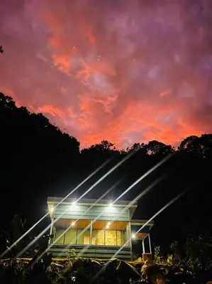 a building with a sunset in the background at Chalet Luna y Miel in Dulce Nombre