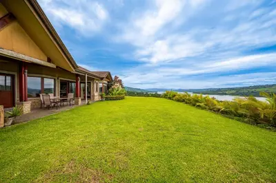 a house with a large yard next to a lake at Casa Shamrock Duplex 1 in Unión