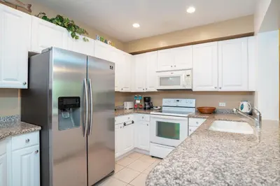 a kitchen with white cabinets and a stainless steel refrigerator at Pacifico TH-104 in Coco