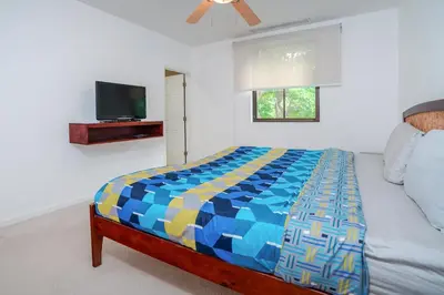 a bedroom with a bed and a flat screen tv at Pacifico TH-104 in Coco