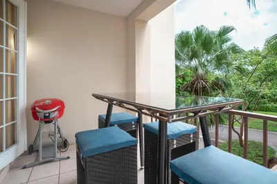 a balcony with a table and chairs and a palm tree at Pacifico TH-104 in Coco