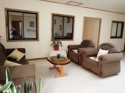 a living room with two couches and a table at Monte Los Lirios Lodge in Monteverde Costa Rica