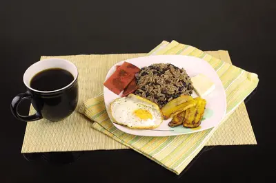 a plate of breakfast food and a cup of coffee at Monte Los Lirios Lodge in Monteverde Costa Rica