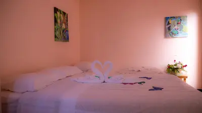 a bedroom with a bed with white sheets and decorations at Monte Los Lirios Lodge in Monteverde Costa Rica