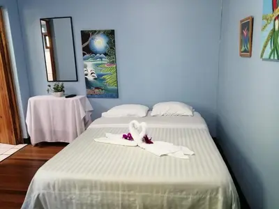 a bedroom with two beds with white sheets and towels at Monte Los Lirios Lodge in Monteverde Costa Rica