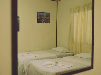 a mirror reflection of two beds in a room at Monte Los Lirios Lodge in Monteverde Costa Rica