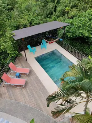 an overhead view of a pool with chairs and a swing at CASA TROPICAL-3 bdrm w private pool Close to beach in Esterillos