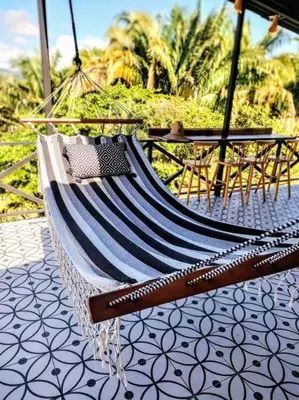 a hammock is hanging on a patio with palm trees at CASA TROPICAL-3 bdrm w private pool Close to beach in Esterillos