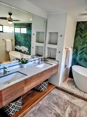 a bathroom with two sinks and a tub and a large mirror at CASA TROPICAL-3 bdrm w private pool Close to beach in Esterillos