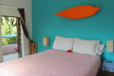 a bedroom with a bed with a blue wall at CASA TROPICAL-3 bdrm w private pool Close to beach in Esterillos