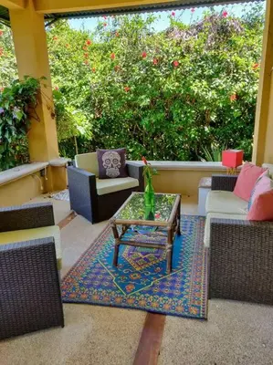 a patio with couches and a table on a rug at CASA TROPICAL-3 bdrm w private pool Close to beach in Esterillos