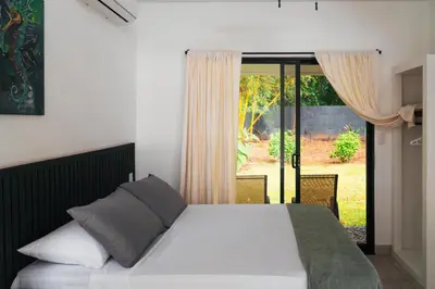 a bedroom with a bed and a sliding glass door at TAMANDUA HOMES el centro de Uvita in Uvita