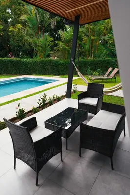 a patio with a table and chairs and a pool at TAMANDUA HOMES el centro de Uvita in Uvita