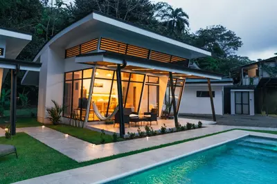a house with a pool in front of it at TAMANDUA HOMES el centro de Uvita in Uvita