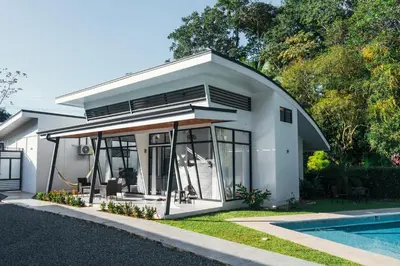 a small white house with a pool at TAMANDUA HOMES el centro de Uvita in Uvita
