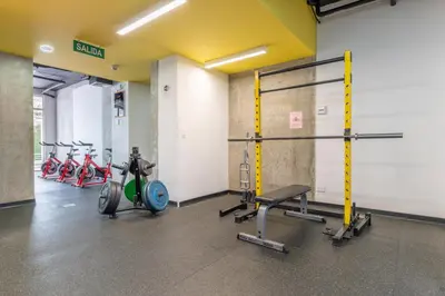 a gym with bikes and weights in a room at Skyline iFreses, 22nd floor! AC, TV and Pool in Guayabos