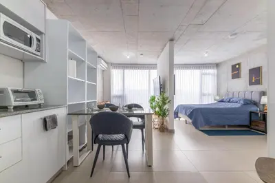 a bedroom with a bed and a desk and a kitchen at Skyline iFreses, 22nd floor! AC, TV and Pool in Guayabos
