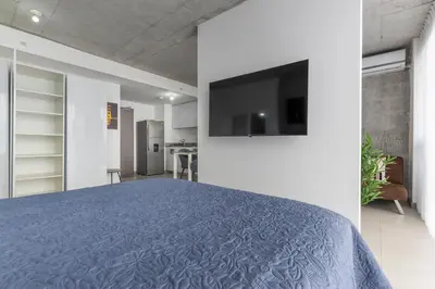 a bedroom with a bed and a tv on a wall at Skyline iFreses, 22nd floor! AC, TV and Pool in Guayabos