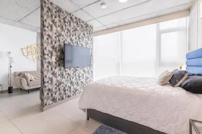 a bedroom with a bed and a tv on a wall at Cityscape iFreses, 20th floor! AC, TV and Pool in Guayabos