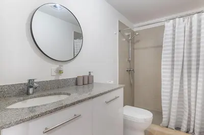 a bathroom with a sink and a mirror and a toilet at Modern Oasis iFreses, 18th floor! AC, TV and Pool in Guayabos