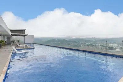a swimming pool with a view of the mountains at Modern Oasis iFreses, 18th floor! AC, TV and Pool in Guayabos