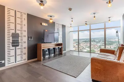 a living room with a tv and a couch at Modern Oasis iFreses, 18th floor! AC, TV and Pool in Guayabos