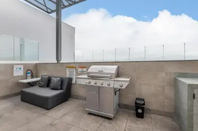 a kitchen with a grill and a chair at Urban Vista iFreses, 2nd floor! AC, TV and Pool in Guayabos