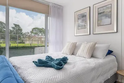 a bedroom with a bed with a blue bow on it at Urban Vista iFreses, 2nd floor! AC, TV and Pool in Guayabos