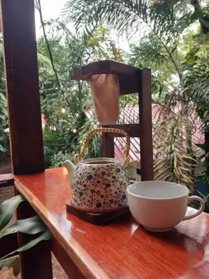 a tea pot and a cup on a wooden table at Cabaña Luna Arenal in Fortuna